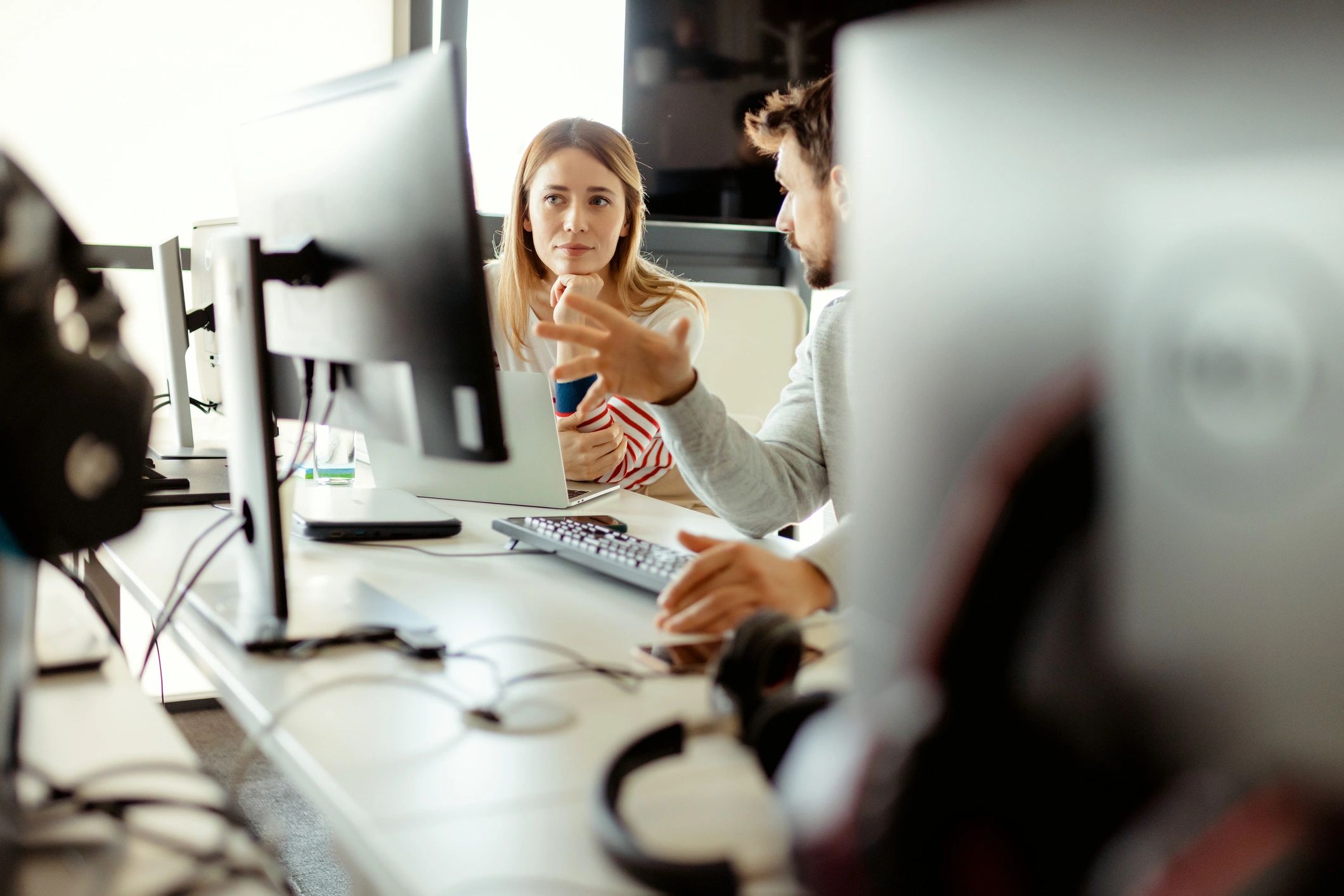 IT support specialists collaborating at a laptop in an office