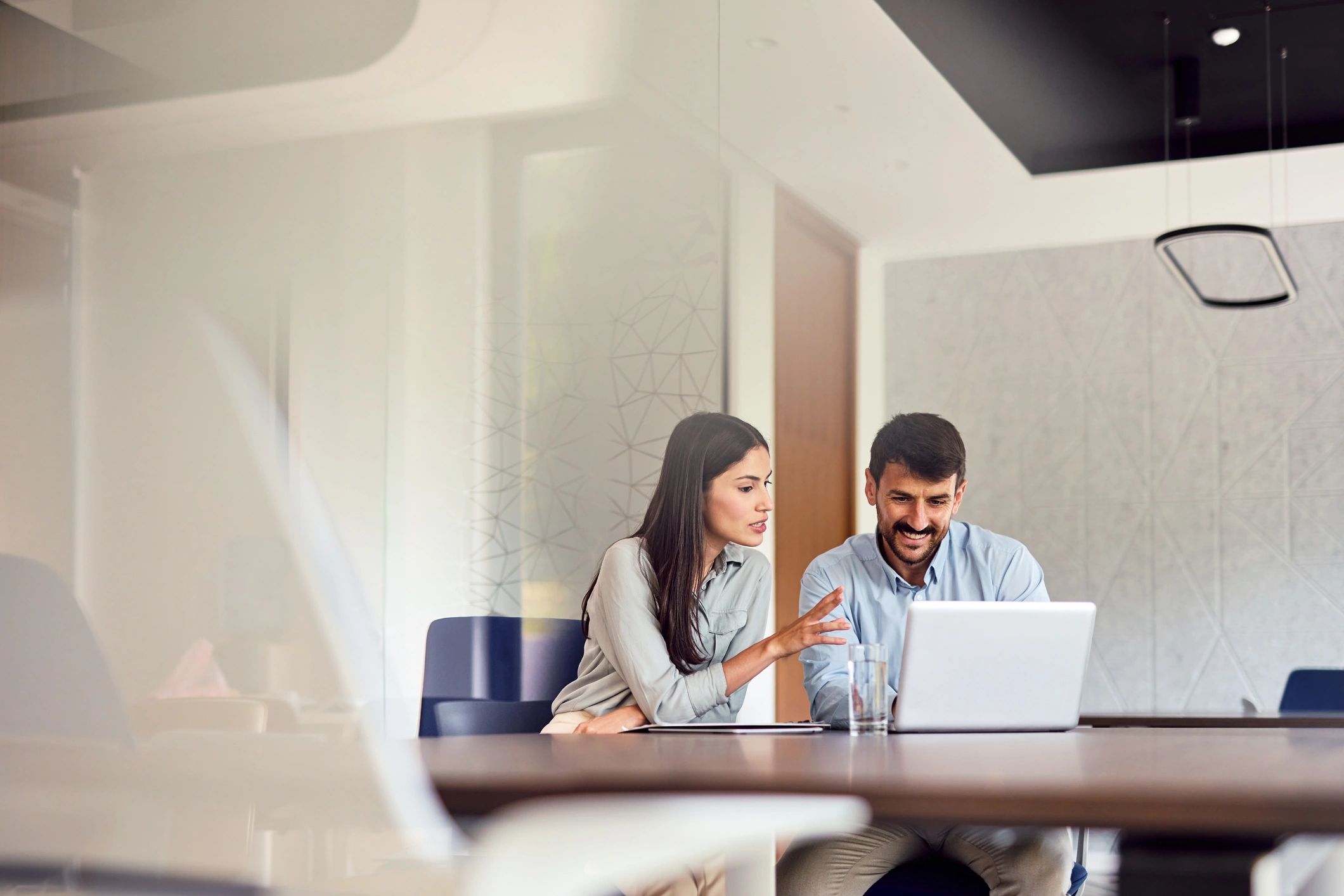 IT consultant working with a client on a laptop